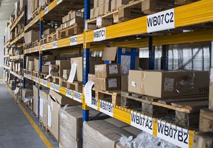 Warehouse storage racks with palletized inventory and location labels for organized inventory management